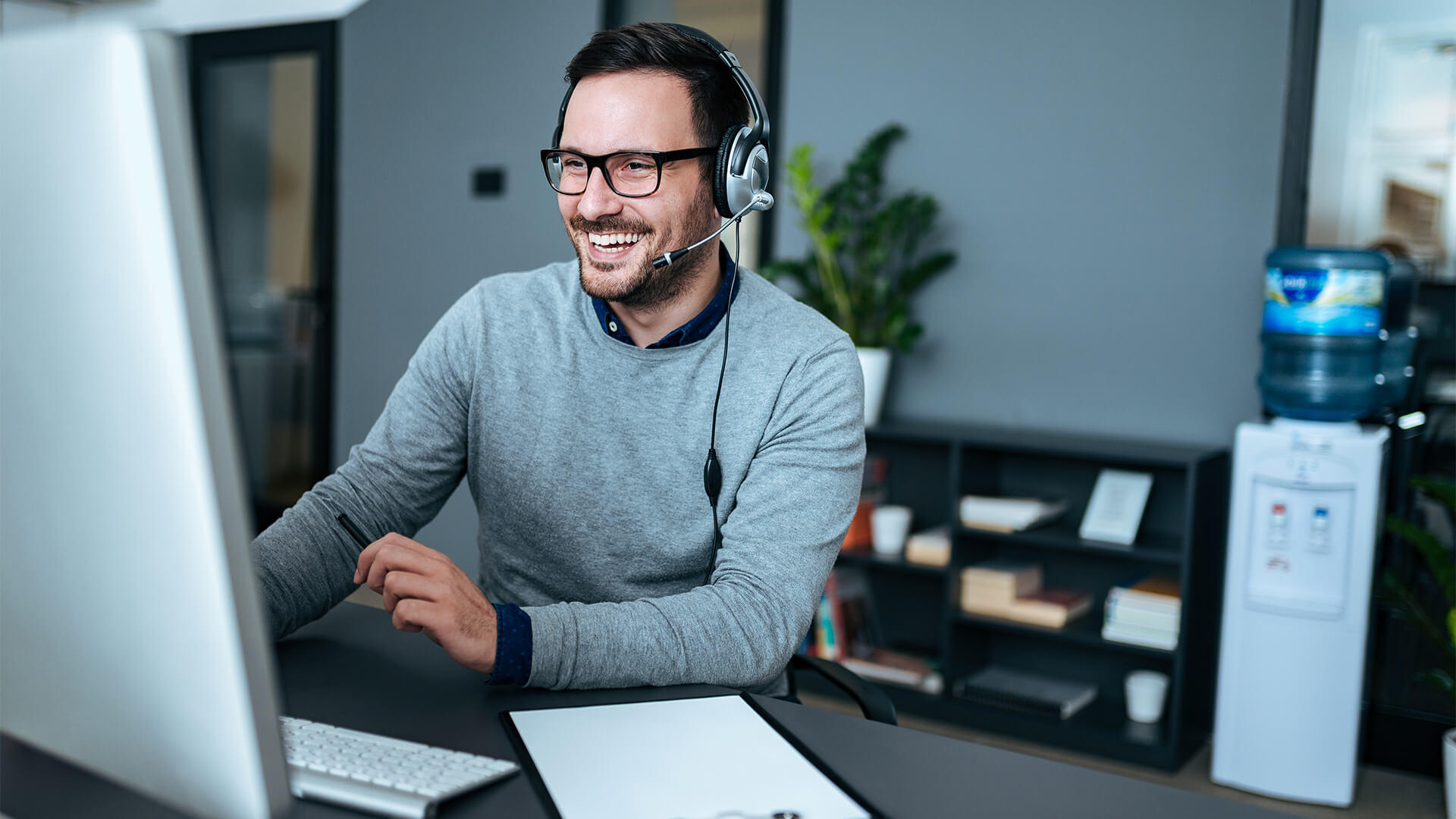 Man working on a computer while on the phone to a client