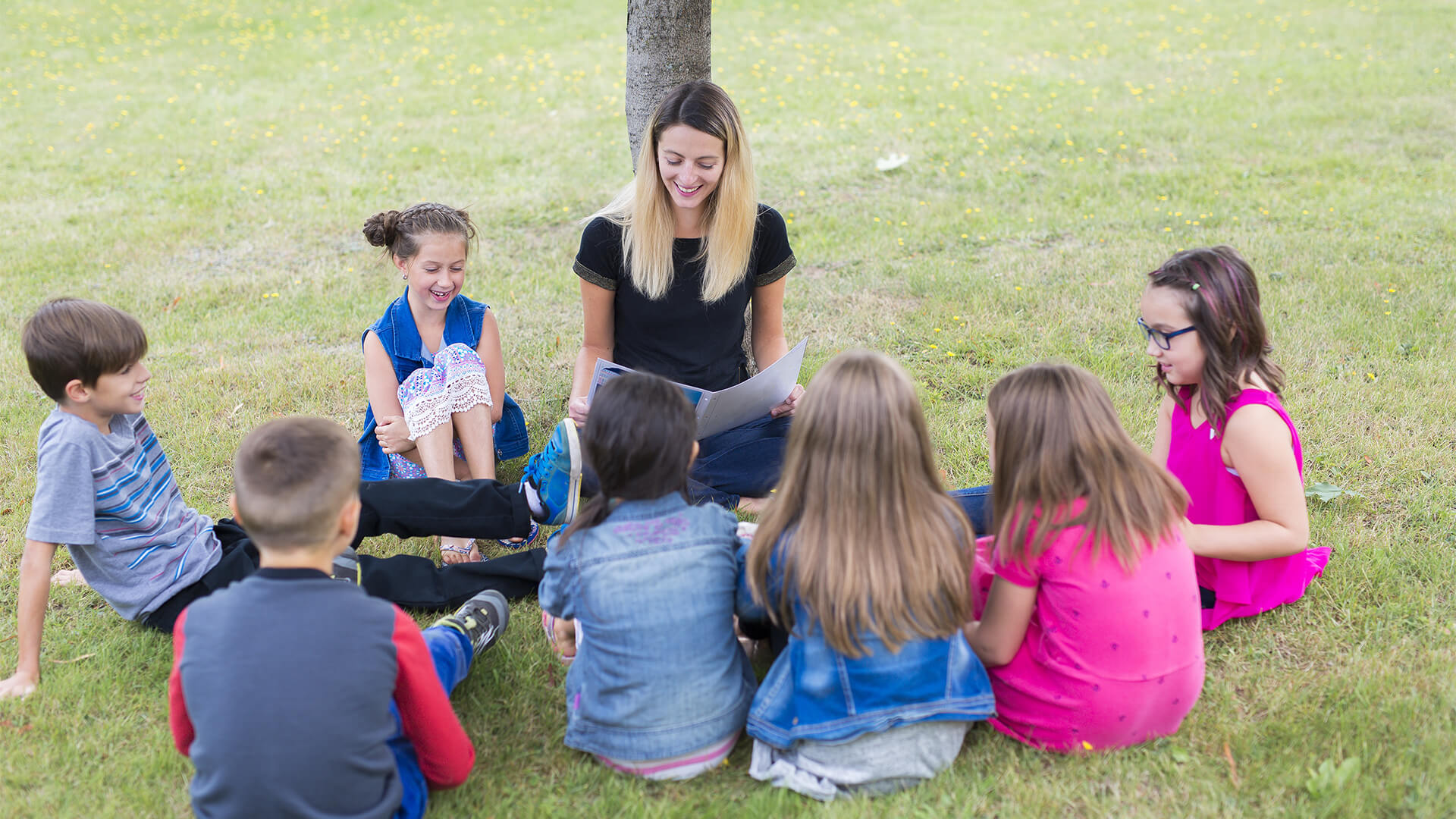 teacher sitting outside with students