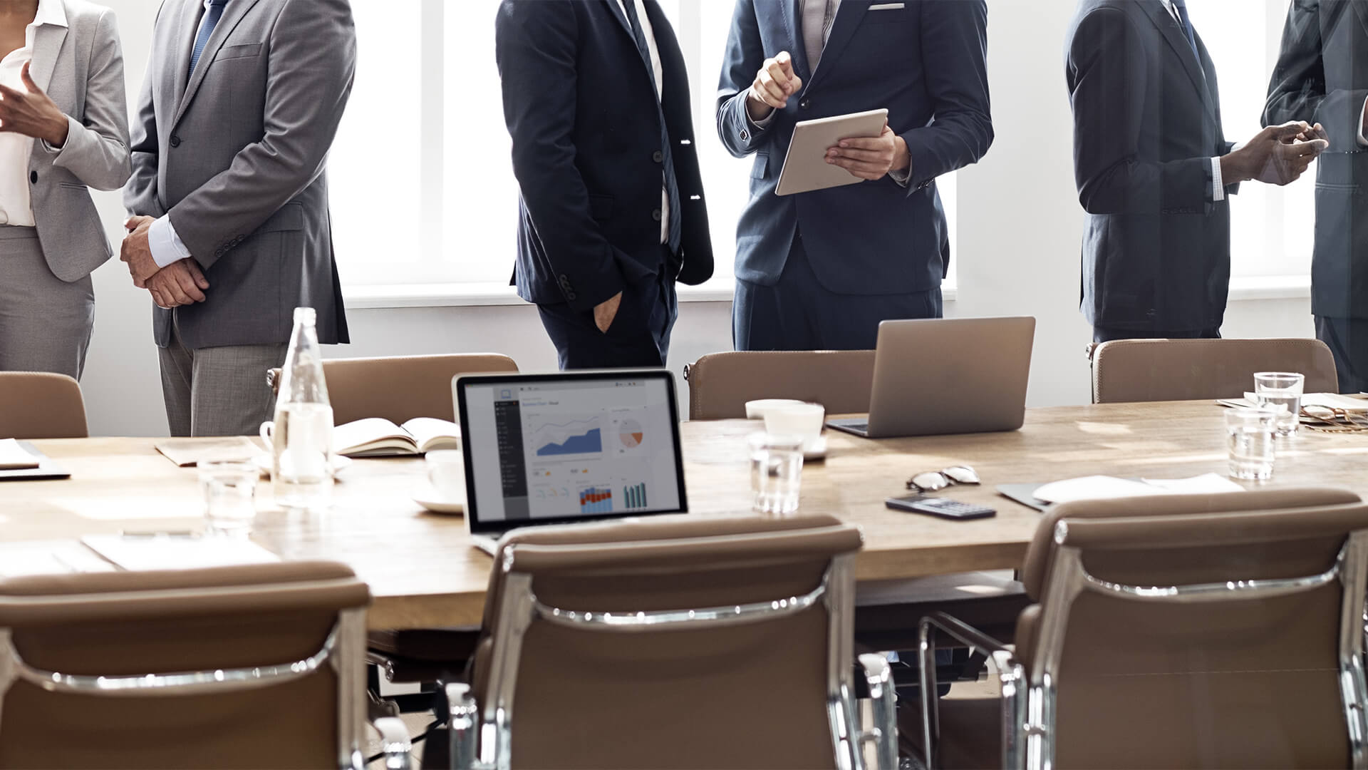 People in suits shaking hands at the end of a meeting