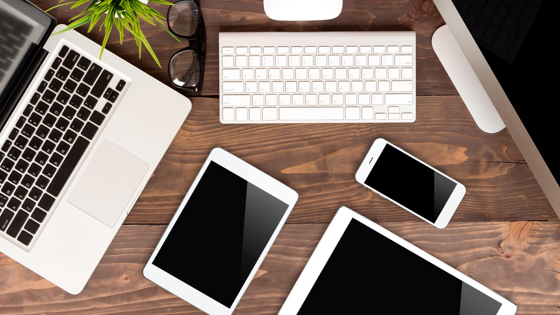 A table top view with electronic devices that may or may not be Apple