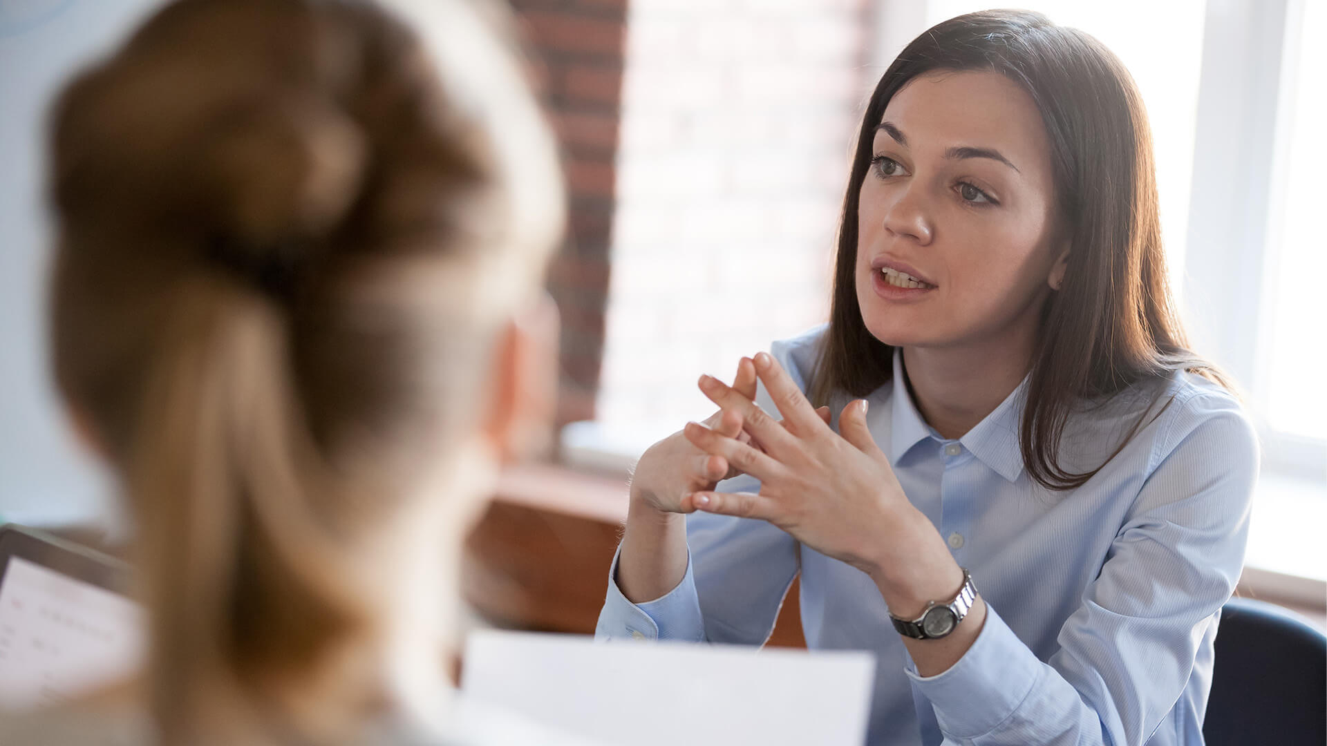 Confident focused businesswoman, teacher or mentor coach speaking to business people at negotiations