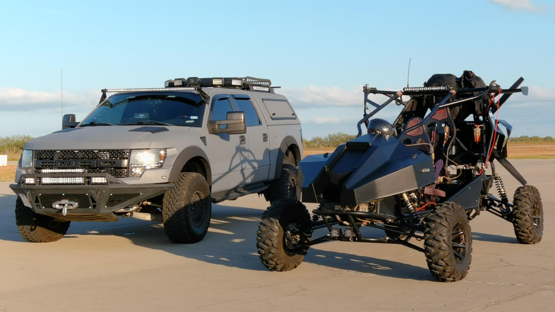 Two vehicles standing next to each other on a long concrete road