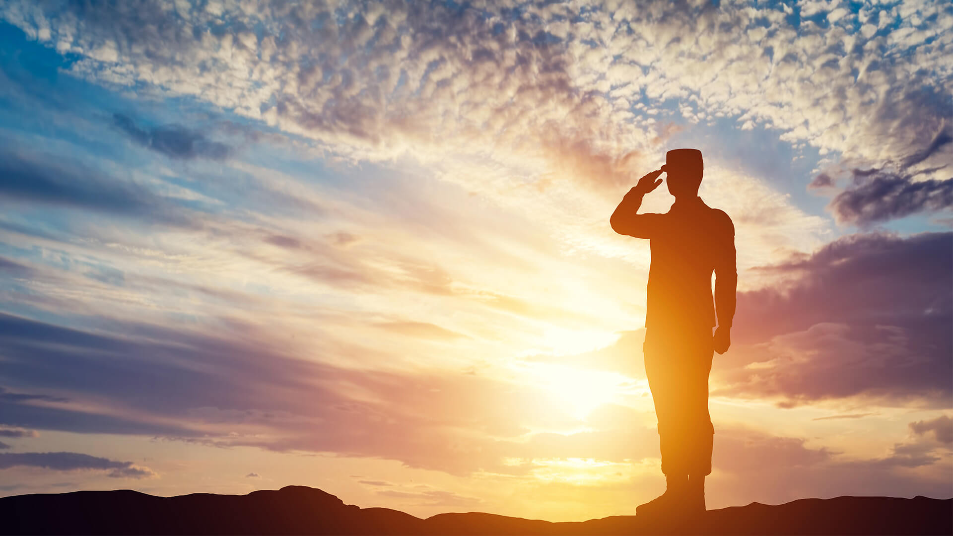 veteran standing in sun set