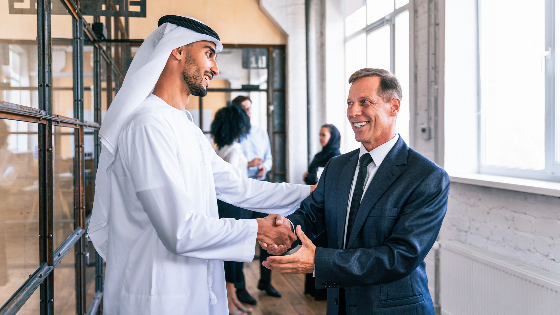 two men shaking hands and smiling