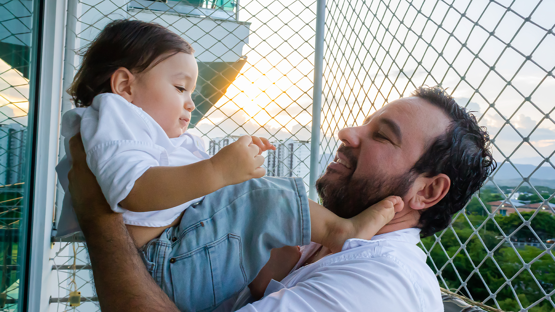 Latino father with beard holding his Hispanic baby son in Neiva