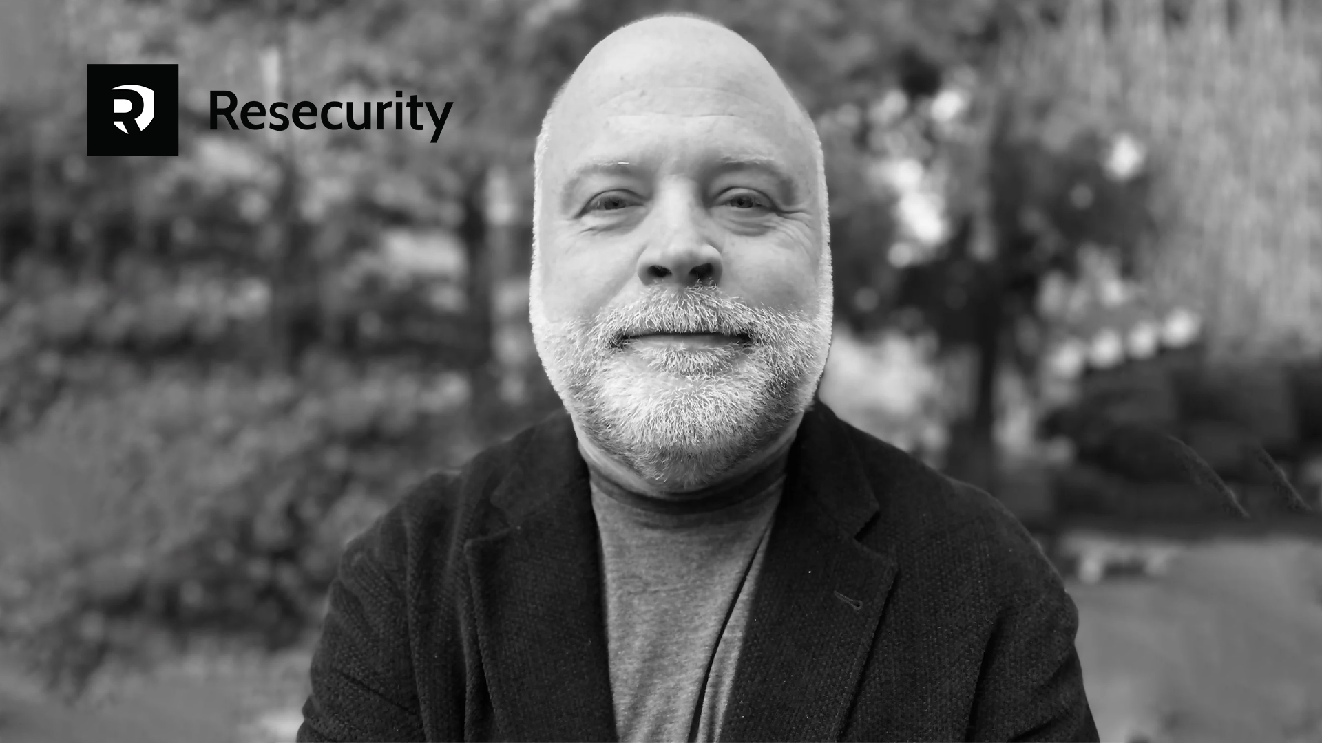 black and white photo of man with beard smiling